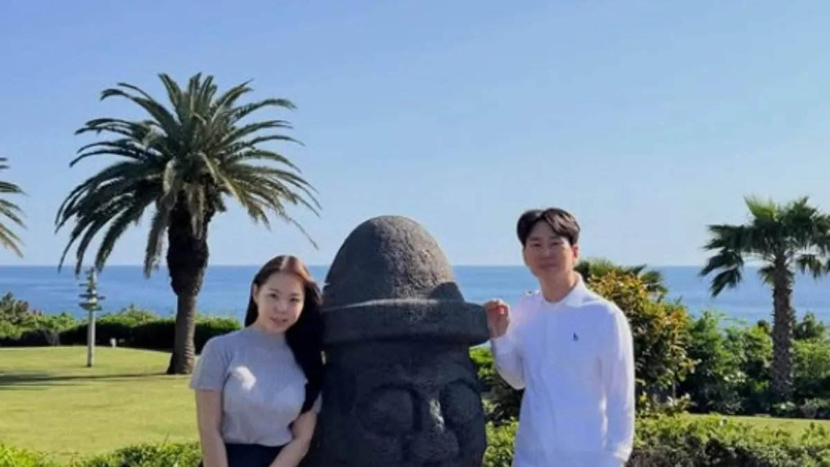 Yeong-ja and Yeong-cheol of 'I Am Solo' Season 32 standing with a Dolhareubang in Jeju
