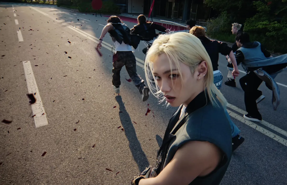 Stray Kids presenta el teaser del MV de "This & That": un miembro mira a la cámara en una escena de carretera